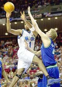 맥그레이디(왼쪽)가 덕 노비츠키를 피해 동료에게 패스를 연결하고 있다.