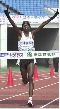 막판 무서운 스퍼트로 투과니를 제친 조시아 벰베(남아공)가 장갑낀 두팔을 번쩍 치켜든 채 1위로 골인하고 있다.