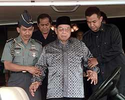 측근들의 부축을 받으며 대통령궁을 나서고 있는 와히드 인도네시아 대통령(가운데)
