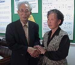 김천만씨의 유족 김성순씨를 만나 손을 맞잡고 있는 배래선씨(왼쪽)