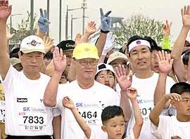 김중권대표(가운데)가 인천 단축마라톤 대회에참석해 시민들과 함께 손을 흔들고 있다