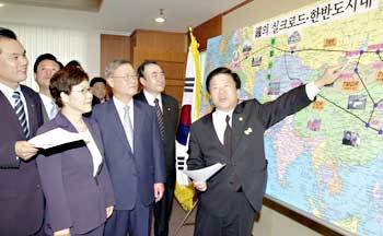 민주 김중권대표가 17일 6·15남북정상회담 1주년 기념유라시아 횡단 철도여행 경로에 대한 설명을 듣고 있다.