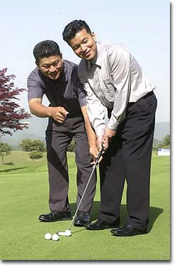 최경주 프로(왼쪽)가 골프를 배우고 싶다는 황영조 감독에게 퍼팅요령을 지도하고 있다.[포천=김동주기자]