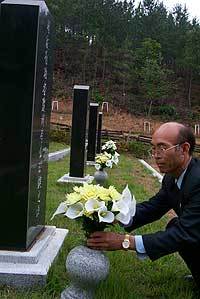 '일가 4형제 국가유공자' 묘소를 찾아 헌화하고 있는 유족 이부건씨.