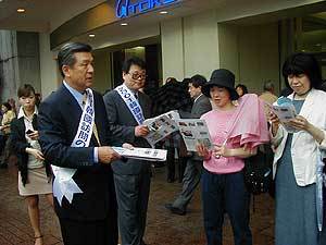 문상주회장(왼쪽)일행이 일본인들에게 한국방문을 권유하는 전단을 나눠주고 있다