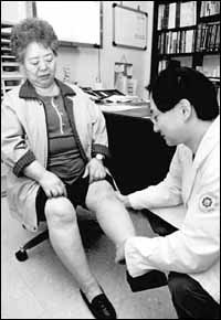 동인천길병원 이수찬 원장이 관절염 증세가 심한 환자의 무릎을 살펴보고 있다.