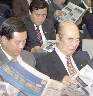 김영배 고문(오른쪽)등이 언론사 세무조사에 대한 한나라당의 입자을 비판한 당보를 보고 있다
