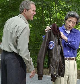 고이즈미 총리(오른쪽)가 부시 대통령이 선물로 준 잠바를 보도진들에게 보여주고 있다