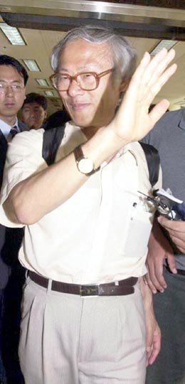 강정구 교수가 21일 김포공항에 도착기자들의 질문에 손을 내젓고있다