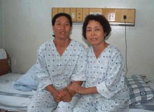 신장을 기증한 전광일씨(왼쪽)가 수술전김윤주씨의 병실을 찾아 함께 손을 잡고있다