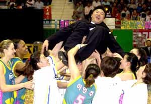 여자프로농구 여름리그 정상에 오른 신세계 선수들이 이문규 감독을 헹가래치며 기쁨을 만끽하고 있다.