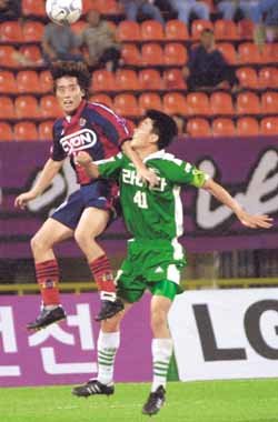 안양 박정환(왼쪽)이 전북 김봉현을 팔로 밀쳐가며 치열한 공둥볼 다툼을 하고 있다