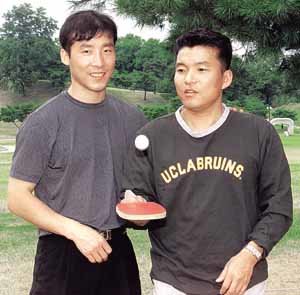 김택수(왼쪽)가 옆에서 장난스럽게 탁구공을 튕겨보이는 황영조를 보며 미소짓고있다.