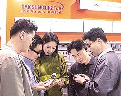 휴대전화 단말기를 살펴보는 '베이징 정보통신전시회'관람객들.