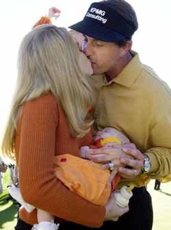 큰 딸을 안은 필 미켈슨(오른쪽)이 생후 4개월 된 둘째딸을 안은 아내에게 축하키스를 받고 있다.