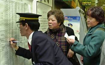 철도노조 파업으로 열차 운행에 차질이 빚어지자 25일 낮 서울역 대합실에서 승객들이 임시열차 운행시간을 확인하고 있다.