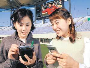 휴대전화 가입자들이 인천 문학 경기장에서 휴대전화와 PDA를 이용해 무선으로 인터넷 정보를 검색하고 있다.
