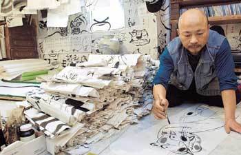 이목일씨가 7500점의 작품이 빽빽이 쌓인 작업실에서 힘찬 붓놀림으로 단번에 한국 호랑이를 그려내고 있다.