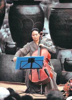 첼리스트 도완녀씨가 장독대 앞에서 첼로를 연주하고 있다.