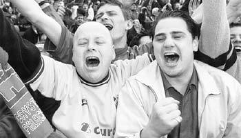 크리스탈 팰리스 축구클럽의 경기를 관전하는 관중들이 열광적으로 응원을 하고 있다.