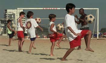 해변가에서 축구의 기본기를 배우고 있는 브라질 어린이들.