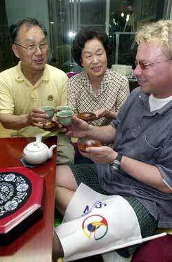 황중규 진경애씨 부부가 민박중인 미국인 론 헨슨(32)에게 녹차를 대접하며 다도(茶道)에 대해 설명하고 있다 신석교기자