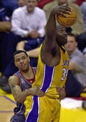 LA레이커스의 샤킬 오닐이 리바운드를 따내자 뉴저지 네츠의 캐년 마틴이 다급한 나머지 오닐의 허리를 잡고 있다.