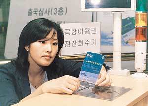9일 대구국제공항을 통해 출국하려는 한 여성이 플라스틱합성재질(PVC)로 만들어진 신 공항이용권을 살펴보고 있다. - 사진제공 데이콤