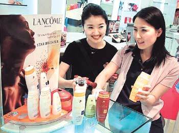 여름 휴가를 앞둔 여성들이 백화점 화장품매장에서 태닝 오일과 자외선 차단제를 고르고 있다. 선탠은 자칫 피부를 상하게 하기 쉬우므로 철저한 준비가 필요하다. [사진제공 롯데백화점]