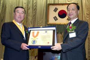 두산 박용오 회장(왼쪽)이 9일 서울 중구 남대문로 대한상공회의소에서 열린 ‘2002 창업대상’ 시상식에서 선친을 대신해 이승욱 한국경영사학회장으로부터 상을 받고 있다. [사진제공 두산]