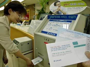 각종 공과금을 창구에서 받지 않는 은행 지점을 찾은 고객이 무인 접수기에 공과금 납부 신청서와 고지서를 넣고 있다. /원대연기자 yeon72@donga.com