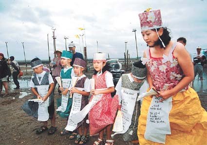 ‘햇살받는 아이들’ 소속 학생과 학부모 등이 11일 경기 평택시 평택호 연안 갯벌에서 열린 ‘평택 해양축제’에 참가해 전통한지 등으로 만든 옷을 입고 시를 낭송하고 있다. 사진제공 햇살받는 아이들