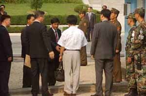 21일 오후 기관장 이경성씨가 북한으로 돌아가기 직전 판문점에서 대한적십자사 직원들의 안내를 받고 있다. - 사진공동취재단