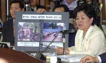 민주당 최영희 의원(오른쪽)이 26일 국회 인사청문특위에서 장대환 총리지명자가 처음 재산신고할 때 누락한 경기 가평의 별장 사진을 들어보이며 질의하고 있다. - 서영수기자