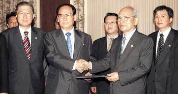 서영훈 대한적십자사 총재(오른쪽)와 북한 조선적십자회 장재언 위원장이 6개항의 남북 합의문을 교환하며 악수하고 있다. - 금강산=사진공동취재단