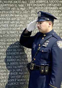 미국 뉴욕 경찰관이 뉴욕 인근 배터리 파크 경찰묘지의 추모비 앞에서 경의를 표하고 있다. - 뉴욕AP연합