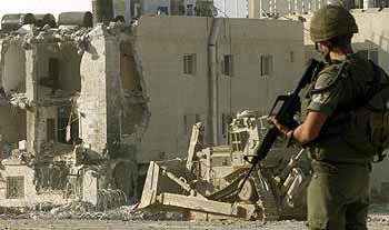 이스라엘 불도저가 야세르 아라파트 팔레스타인 자치정부 수반 집무실 부근의 건물을 부수고 있는 것을 이스라엘 병사가 쳐다보고 있다. - 라말라AP연합
