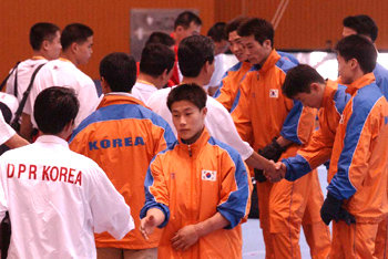 ‘반갑습니다.’ 24일 부산 사직동 양정모체육관에서 남북한 남자체조선수들이 훈련에 들어가기 직전 한데 모여 악수를 나누고 있다.