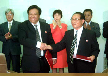 신의주 특구 초대 행정장관에 임명된 양빈 어우야그룹 회장(왼쪽)과 김용술 조선대외경제협력추진위원장이 23일 평양에서 ‘신의주 특구 개발과 관리운영을 위한 기본합의서’에 서명한 뒤 악수하고 있다. AP연합