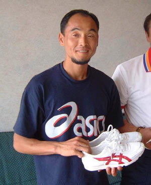 이봉주가 자신을 위해 특수제작된 아식스 마라톤화를 들어보이며 미소짓고 있다.