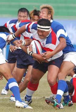 '막히면 뚫고’. 9일 울산공설운동장에서 열린 럭비 15인제 경기에서 한국의 라이트윙 최창렬(머리띠 두른 선수)이 대만 수비수들의 태클을 뿌리치고 있다. 한국은 50-15로 이겨 2승을 기록하며 은메달을 확보했다. 한국은 13일 일본과 최종전을 갖는다.울산=이종승기자