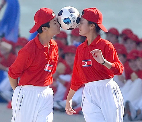 북측 응원단 남녀가 `통일 축구공'으로 `공  이마에 맞대고 달리기' 시합을 하고 있다. [연합]