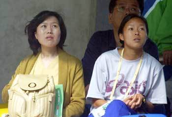 '간절한 우승염원.' 이봉주의 부인 김미순씨(왼쪽)가 여자마라토너 권은주와 함께 부산아시아드 주경기장에서 전광판을 통해 중계되는 남편의 레이스 모습을 가슴졸이며 지켜보고 있다. - 부산 = 이종승기자