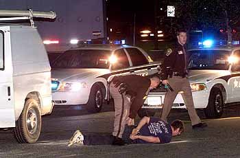 미국 경찰이 버지니아주 스탠퍼드의 한 주유소에서 흰색 밴을 타고 가던 한 남자를 바닥에 누인 채 수갑을 채워 체포하고 있다. - 스탠퍼드(미 버지니아주)로이터연합