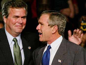 조지 W 부시 미 대통령(오른쪽)이 탬파에서 열린 플로리다 주지사 선거 유세장을 방문해 주지사 후보이자 자신의 동생인 젭 부시 주지사와 뭔가 얘기를 나누고 있다. - 탬파로이터뉴시스