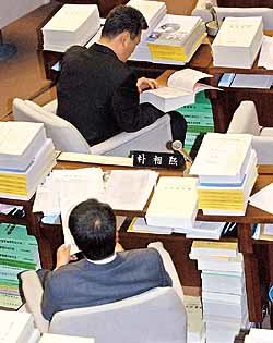 국회 예산결산특별위원회에서 소속 위원들이 책상 가득 서류더미를 쌓아 놓고 검토작업을 하고 있다. - 동아일보자료사진