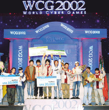 WCG2002에서 종합 1위를 차지한 한국 선수들이 3일 대전 엑스포 과학공원 폐막식에서 시상이 끝난 뒤 꽃다발과 상품목록이 적힌 피켓을 들어 보이고 있다.사진제공 WCG2002 운영위원회
