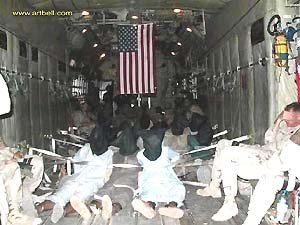 테러 용의자로 보이는 사람들이 두건을 쓰고 수갑을 찬 채 앉아 있는 미군 수송기 C130 내부 사진이 7일 한 인터넷방송 웹사이트에 공개됐다.아트벨 제공