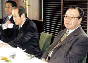 자민련 김종필 총재(오른쪽)가 서울 여의도의 한 음식점에서 당 소속 의원들과 오찬을 하며 당 진로를 협의하기에 앞서 심각한 표정으로 앉아있다. - 서영수기자
