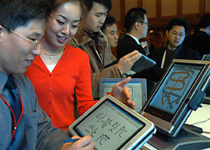 최근 서울 신라호텔에서 열린 태블릿PC 신제품 발표회장에서 관람객들이 태블릿PC에 손으로 글씨를 쓰고 있다.사진제공 마이크로소프트